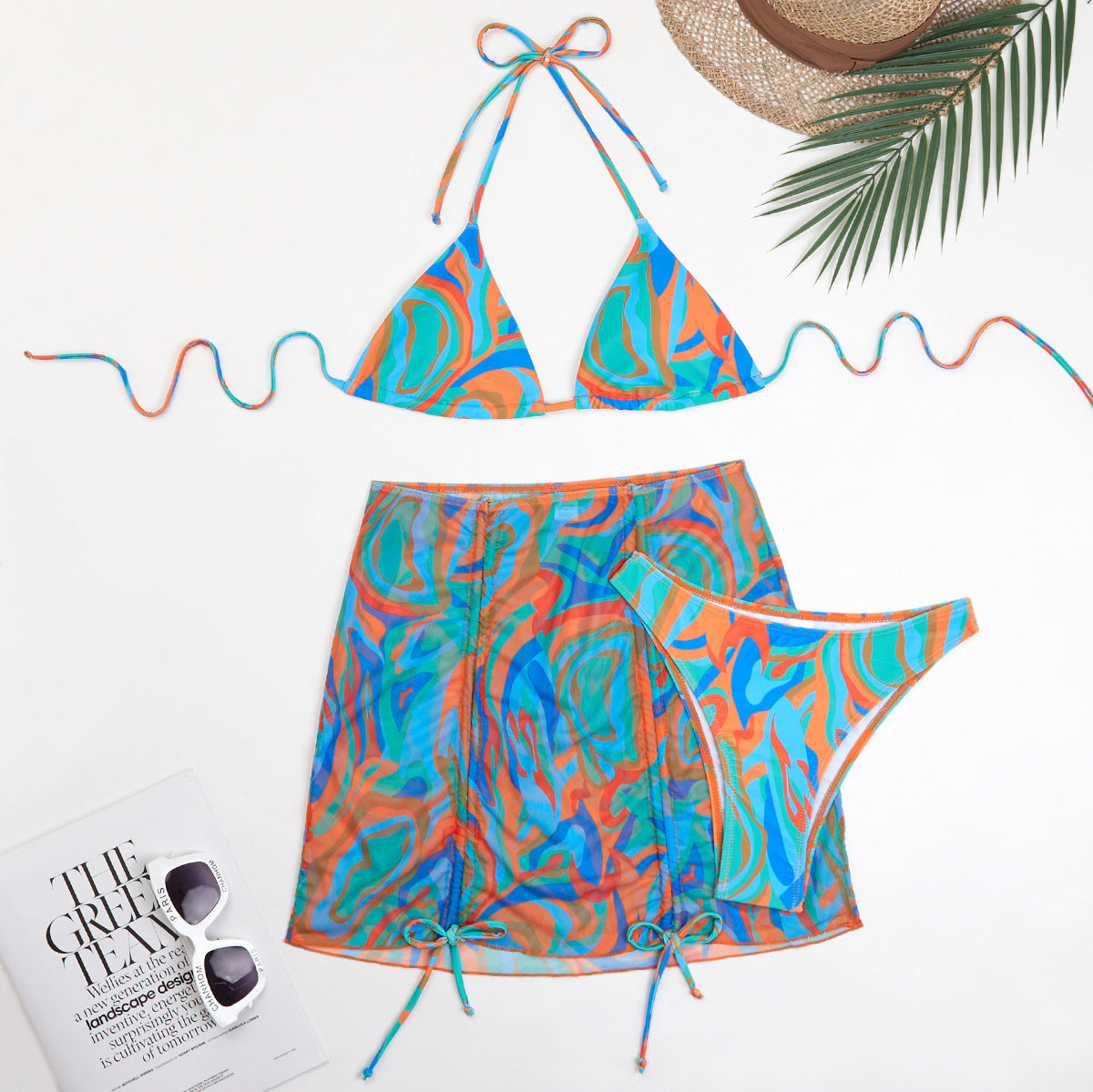 Modernes Damen-Bikini-Set mit Dreieck-Oberteilen, halbtransparentem Wickelrock und buntem Berg-Feld-Muster